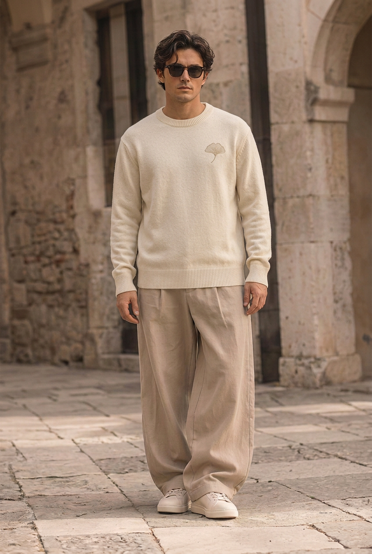 Herick & Belle City Explorer ivory ginkgo knit worn by male model in stone courtyard